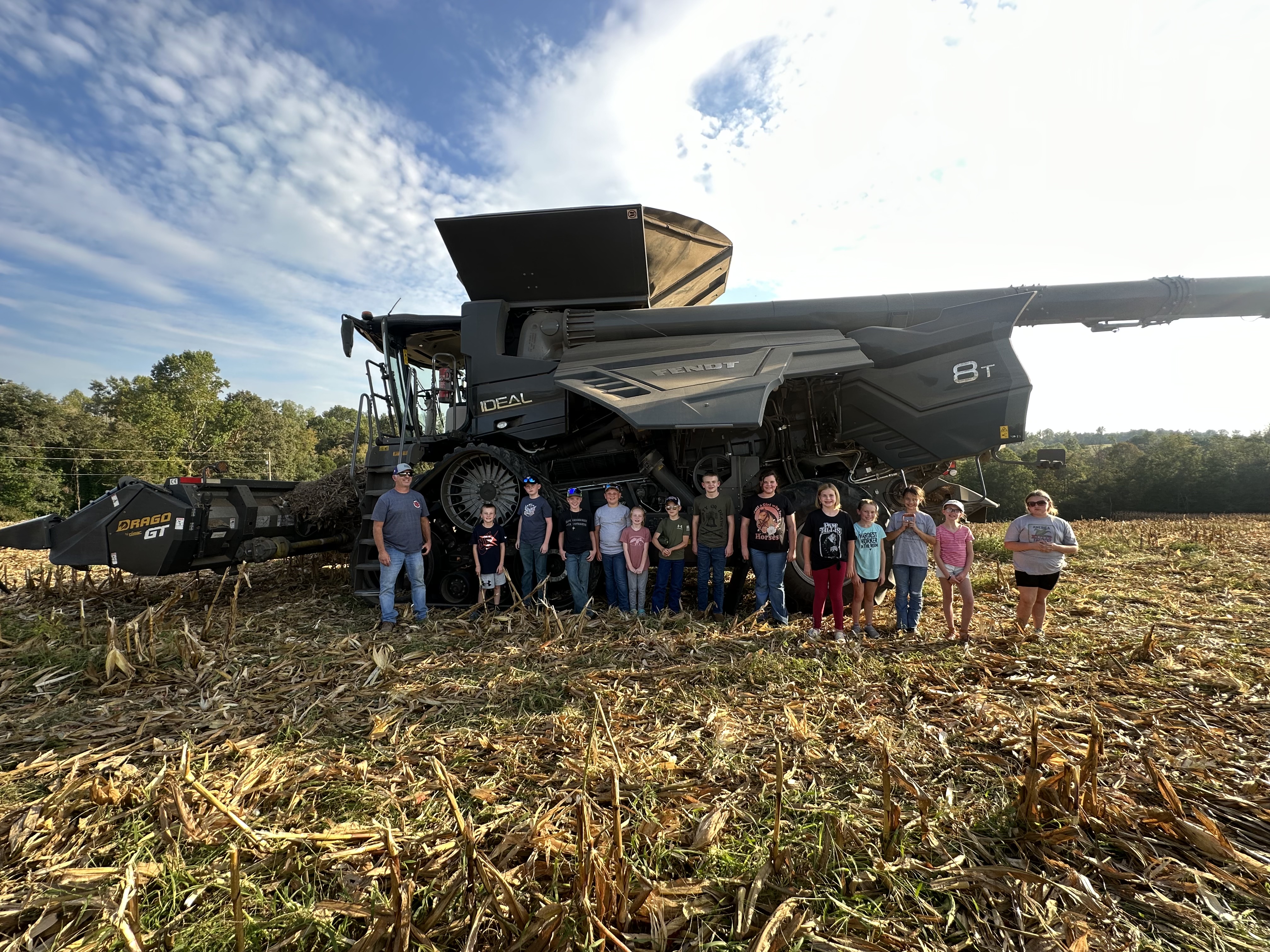 children in front of a combine